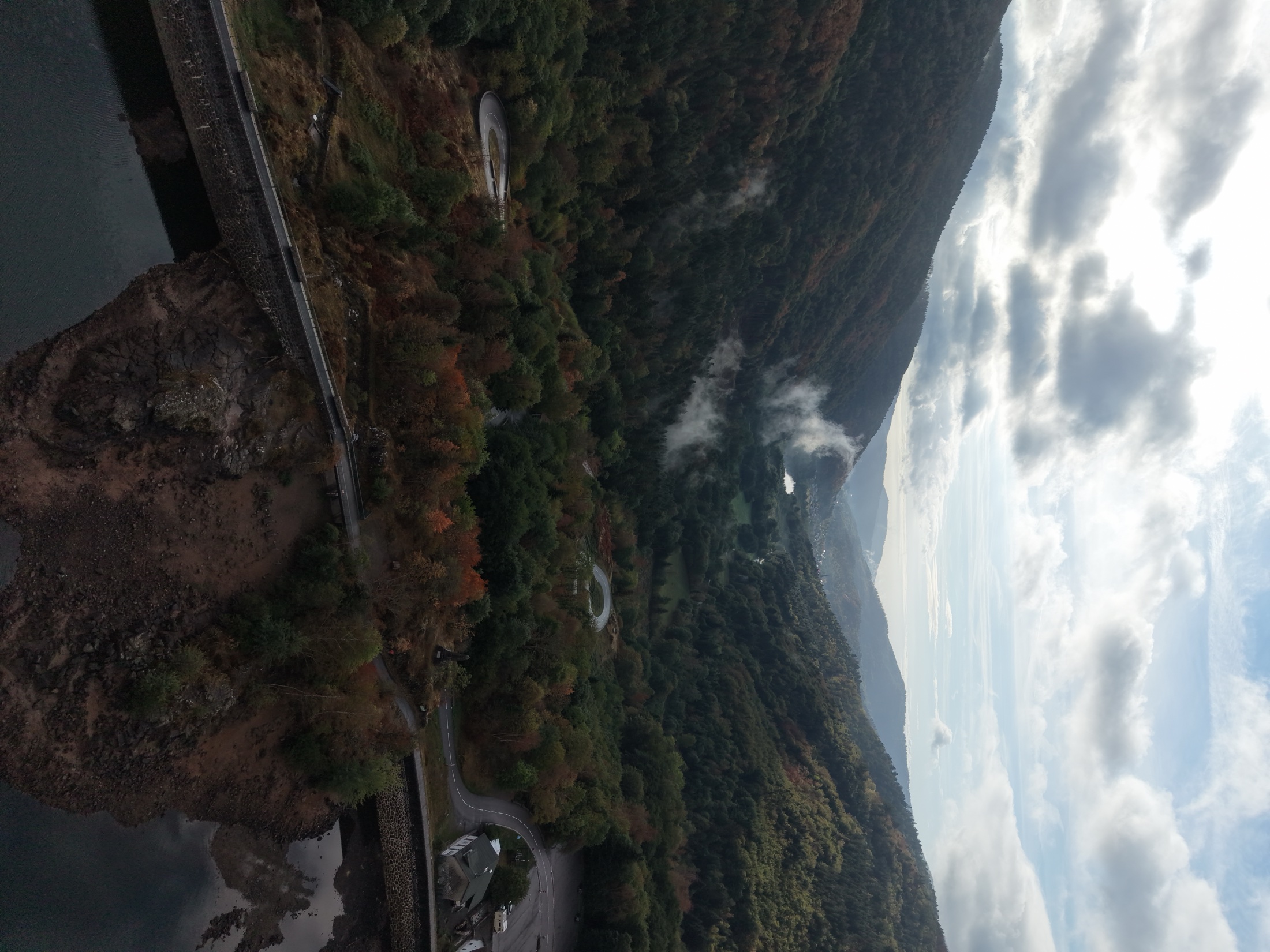 Vue aérienne d'une vallée boisée traversée par la brume